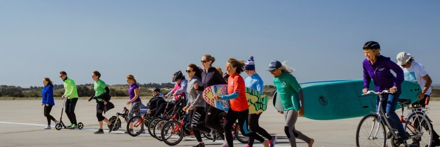 People dressed in different outfits starting a run on an airport runway
