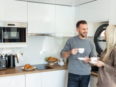 Two people drinking a cup of tea in the kitchen